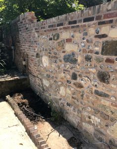 The completed flint stone wall in Chichester blending into the old part of the wall