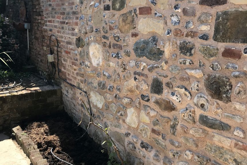 The completed flint stone wall in Chichester blending into the old part of the wall